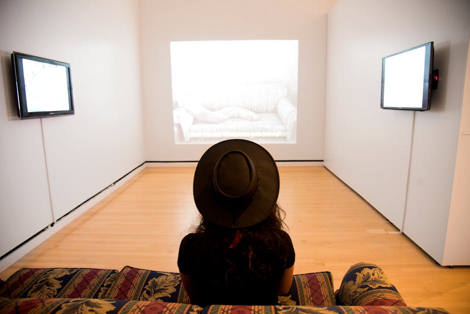 Kırmızı Yeşil Süet Koltukta Oturan İyi Aydınlatılmış Odaya Bakan Kadın