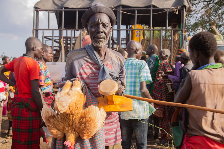 Geleneksel kıyafetler giyen, hayvanlarını ve mallarını tutan insanların sergilendiği canlı pazar manzarası.