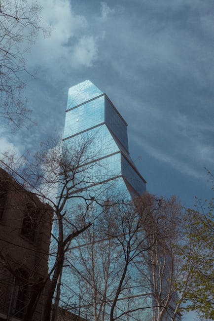 Gürcistan'ın Tiflis şehrinde, yapraksız ağaçların arasında, masmavi bir gökyüzünün altında camdan bir gökdelen yükseliyor.