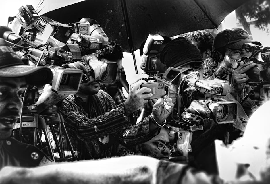 Dakka'da bir grup fotoğrafçı, kamera ve şemsiyelerle bir olayı fotoğraflıyor.