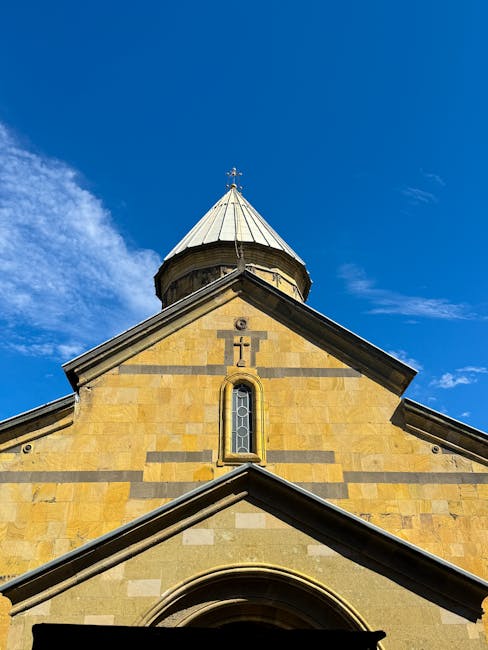 Canlı mavi gökyüzü fonunda, kendine özgü mimari kubbesiyle dikkat çeken tarihi bir kilise.