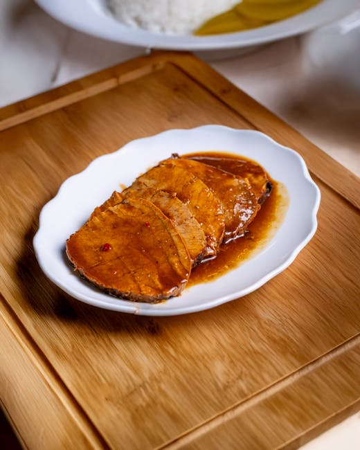 Ahşap bir tezgah üzerinde lezzetli soslu yumuşak rosto dana dilimleri.