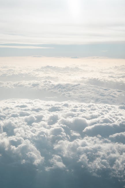 Güneş ışığı altında yıkanan kabarık bulutların oluşturduğu dingin bir manzarayı yakalayan bir hava fotoğrafı.