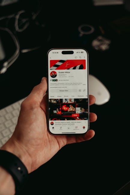 Koyu ve modern görsellerle mobil uygulama arayüzünü görüntüleyen akıllı telefonu tutan bir el.