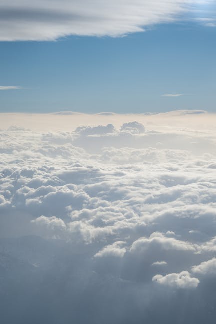 Berrak mavi gökyüzünün altında kabarık beyaz bulutların büyüleyici hava fotoğrafı.