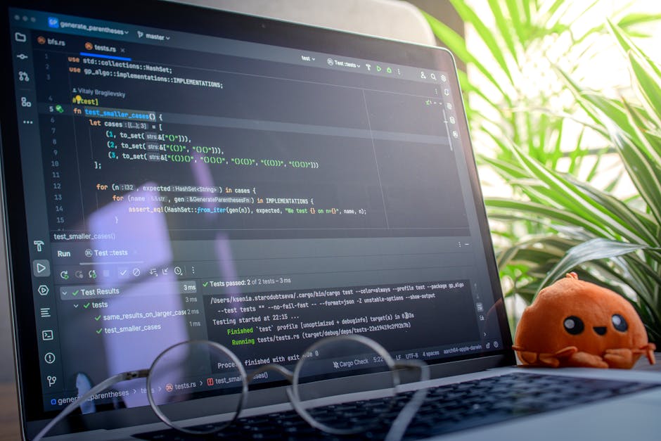 Bitkilerle dolu aydınlık bir odada, peluş oyuncağın yanında kod gösteren açık dizüstü bilgisayar.