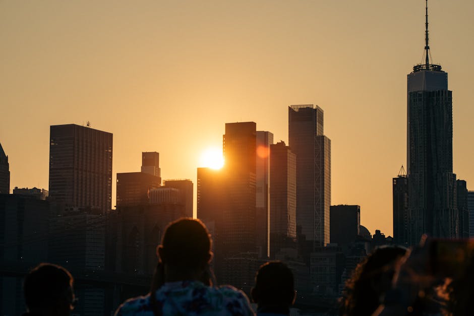 Gün batımında New York silüetinin büyüleyici manzarası, modern mimariyi sergileyen silüet halindeki insanlarla birlikte.