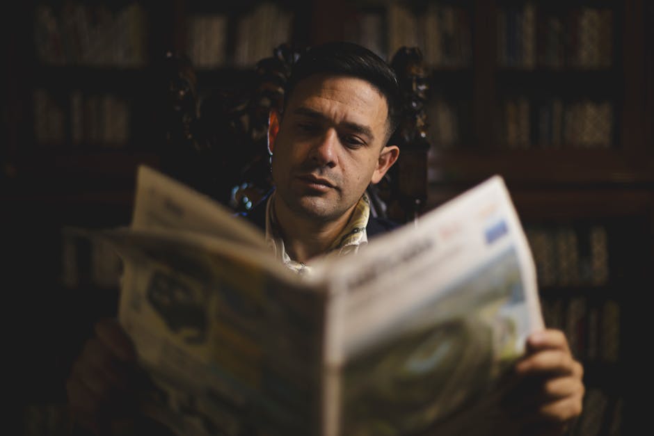 Buenos Aires'in klasik bir kütüphanesinde gazete okuyan yetişkin bir adam.