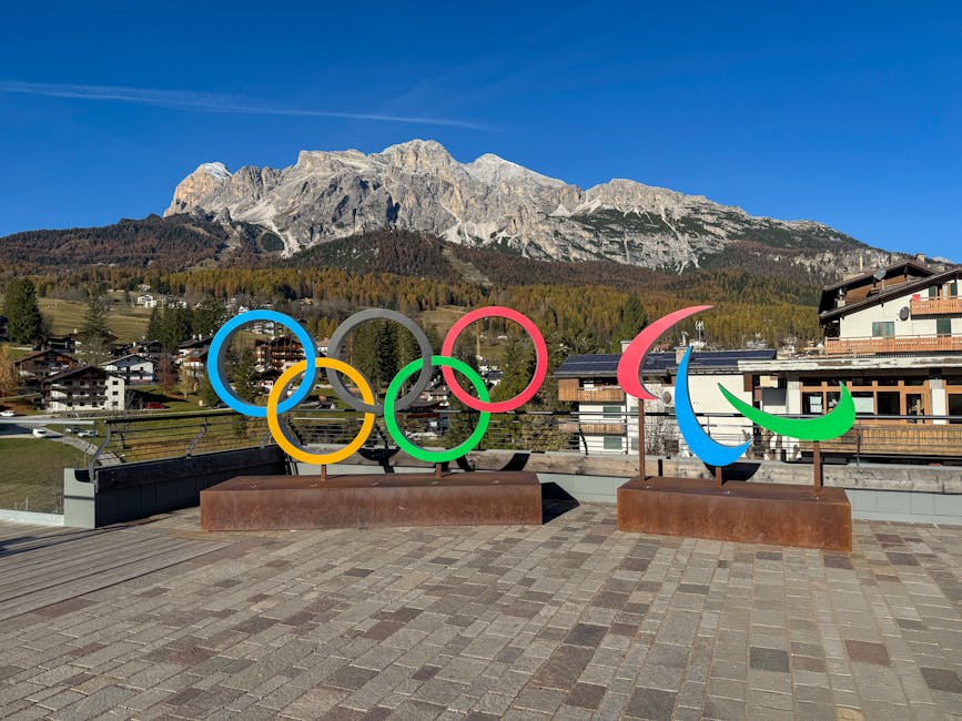 Cortina d'Ampezzo'da İtalyan Alpleri'ne karşı Olimpiyat ve Paralimpik sembollerinin muhteşem manzarası.