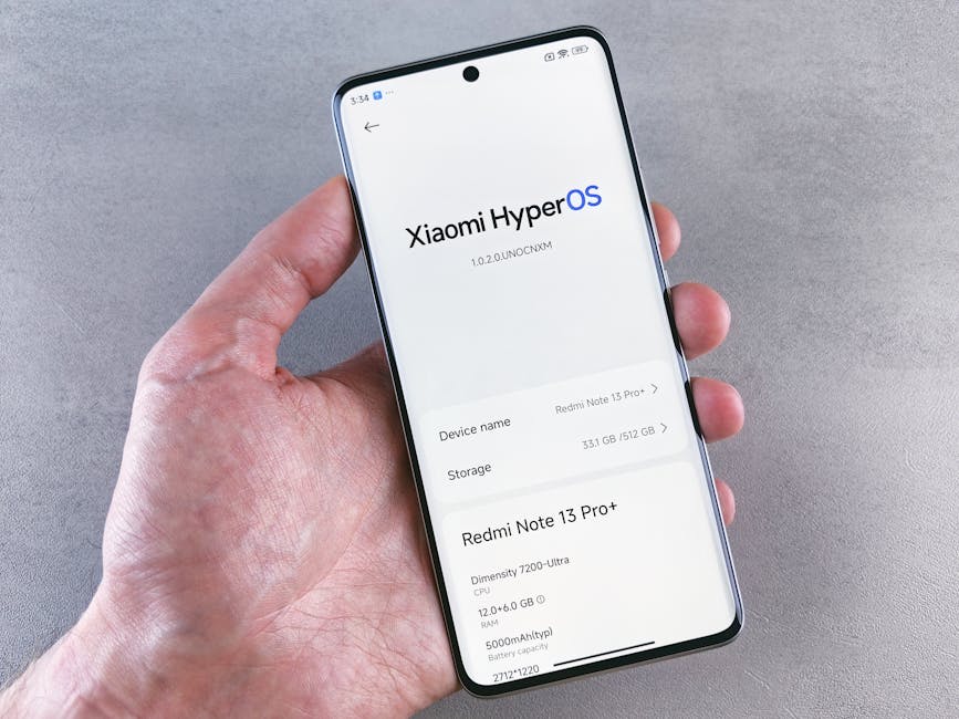 Ekranında Xiaomi HyperOS'u gösteren bir akıllı telefonu tutan bir elin yakın çekimi.