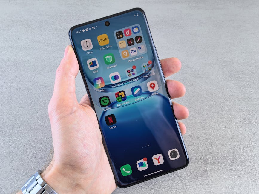 Çeşitli uygulama simgelerini görüntüleyen, modern teknolojiyi ve mobil arayüzü sergileyen bir akıllı telefonu tutan bir elin yakın çekimi.