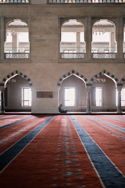 Ankara'daki geniş Kocatepe Camii'nin iç görünümü ve tefekkür halindeki yalnız bir figür.