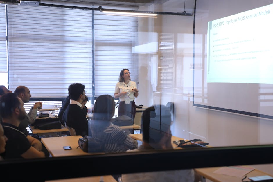 Modern bir ofis ortamında iş sunumuna katılan izleyiciler.