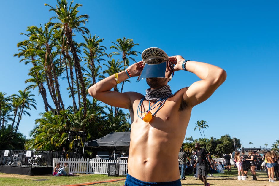 Genç adam, aynalı vizör takarak güneşli açık hava müzik festivalinin tadını çıkarıyor.