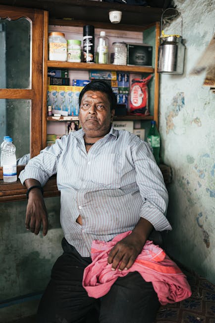 Hindistan'ın Varanasi kentindeki bir dükkânda yerel ürünlerin sergilendiği bir adamın samimi portresi.