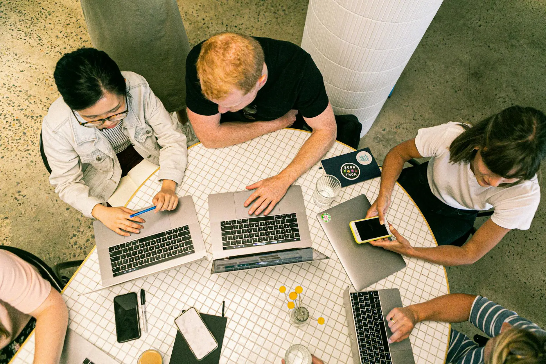 Development team collaborating on laptops in a modern workspace