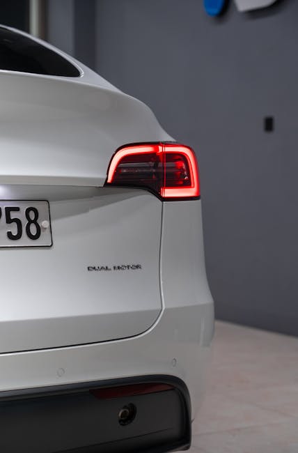 Çevre dostu teknolojiyi ön plana çıkaran aydınlatmalı arka lambalara sahip şık, modern beyaz elektrikli otomobil.