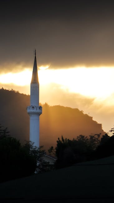 Türkiye'nin Niksar kentinde, tepeler ve etkileyici bulutlarla gün doğumunda minarenin muhteşem manzarası.