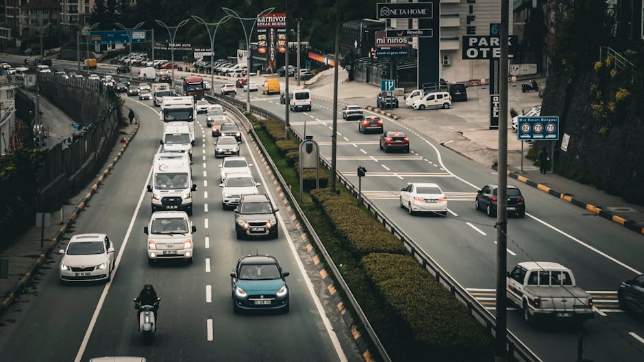 Türkiye'nin Trabzon kentinde çeşitli araçların ve tabelaların sergilendiği hareketli bir otoyol manzarası.