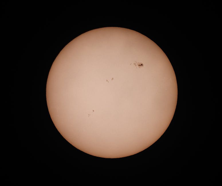 Güneşin koyu bir arka plan üzerinde görünen güneş lekelerini vurgulayan detaylı bir fotoğrafı.