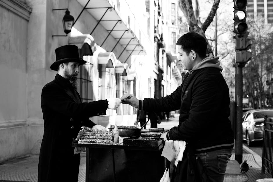 Buenos Aires'te bir sokak satıcısının ve müşterinin mal alışverişi yaptığı siyah beyaz fotoğraf.