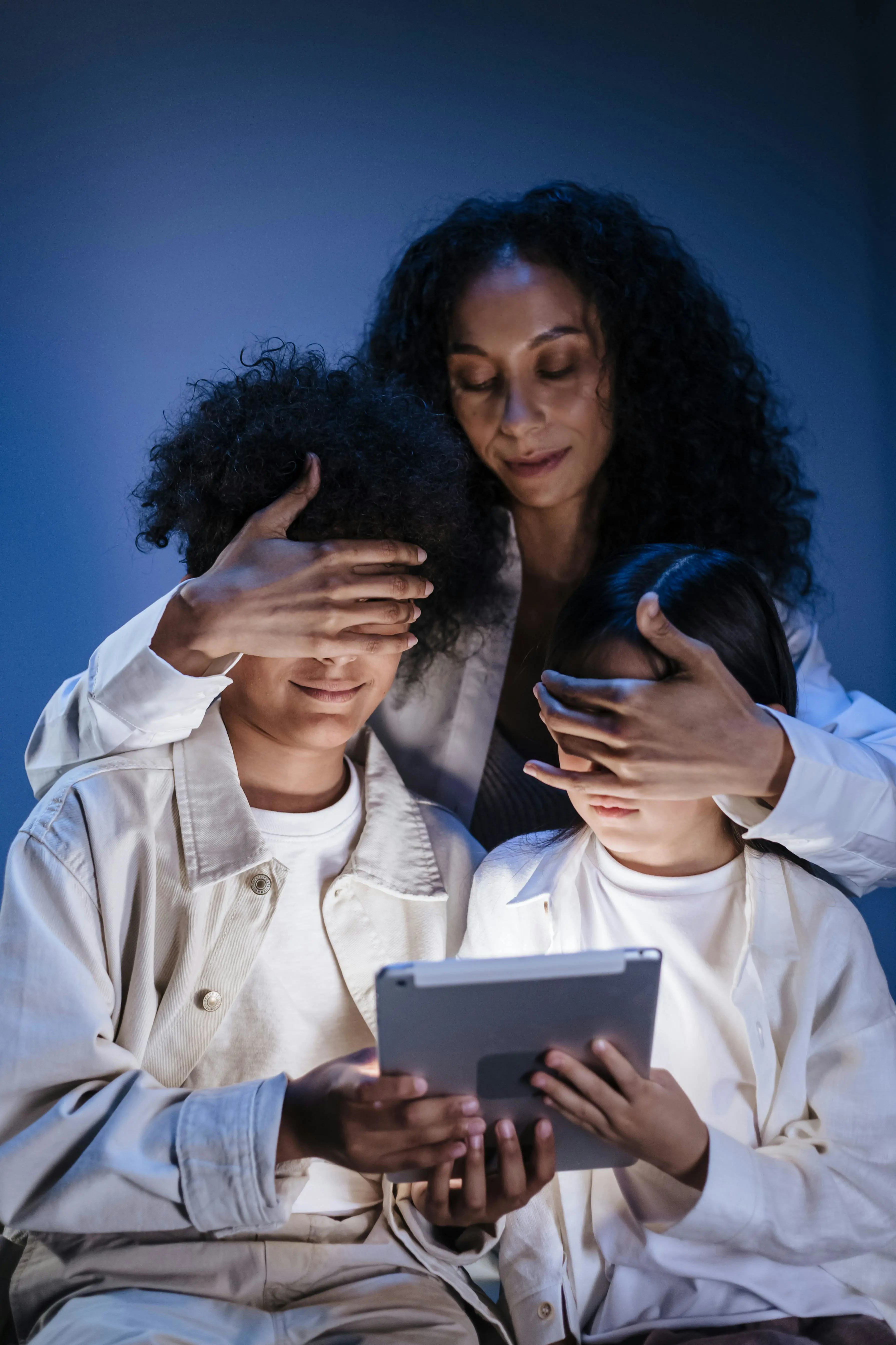 Mother supervising children using a tablet for digital safety